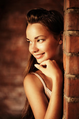 Fototapeta premium Beautiful woman near brick wall