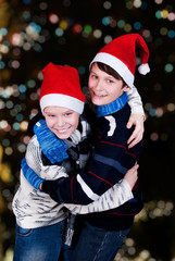 two happy young boys on Christmas lights the background