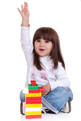 Cute little girl is constructing using building blocks