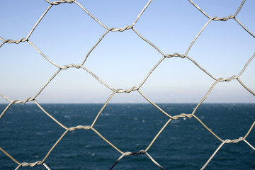 Detail of wire netting in front of sea