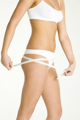 Fototapeta premium detail of woman wearing underwear with tape measure