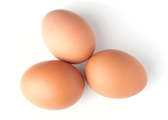 Three brown eggs on white background