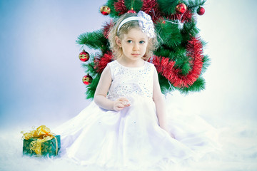 cute girl wearing snowflake costume under xmas tree