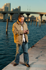Handsome Hispanic man in a lifestyle pose with a mobile phone