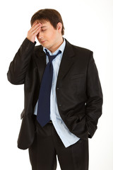 Young businessman with headache holding hand at head
