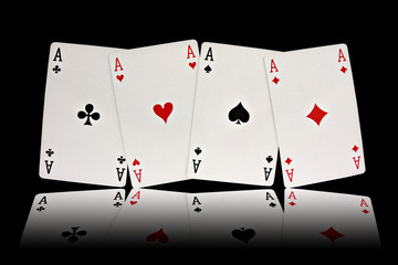 four aces playing cards suits on black background