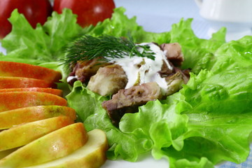 Tasty fish with lettuce and pieces of apple on the plate