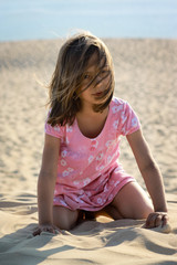 fillette à genoux dans le sable