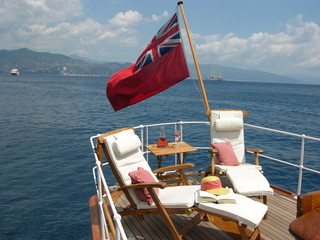 Obraz premium Classic Yacht aft deck with sun loungers and British ensign flag