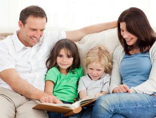 Obraz premium Cute girl and her family looking at a photo album