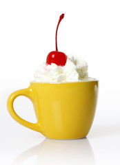 yellow cup with cream and cherry