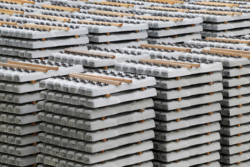 Concrete railway sleepers piled in a factory yard