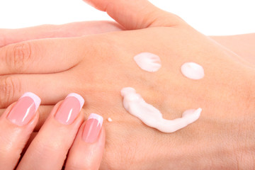 Obraz na płótnie Canvas Closeup of beautiful female hands applying hand cream isolated o