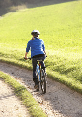 Fototapeta premium Young woman rides her bike in park