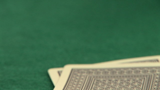 Hand holding pocket aces with poker chips
