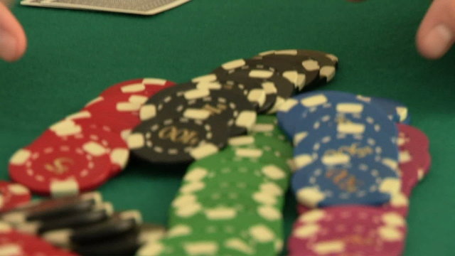 Hands betting chips while holding playing cards