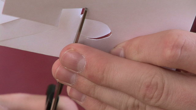 Close Up Of Male Hands Cutting Out Paper Dolls