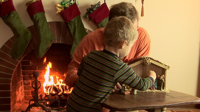 Father and son with nativity scene at Christmas