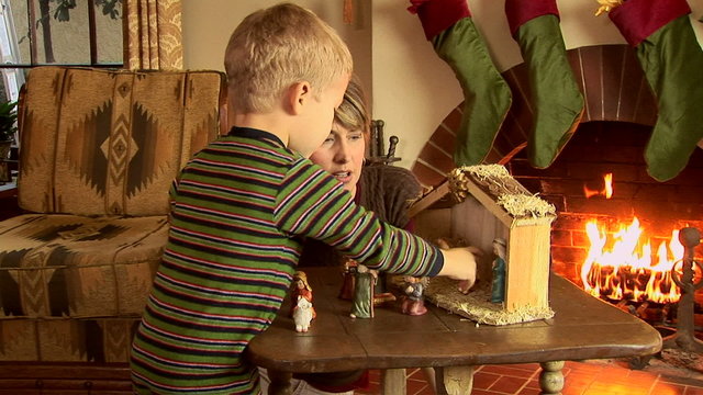 Mother and son with nativity scene at Christmas