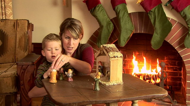 Mother and son with nativity scene at Christmas