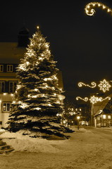 Beleuchteter Weihnachtsbaum im Schnee bei Nacht