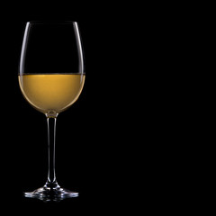 A glass of white wine, isolated on a black background.