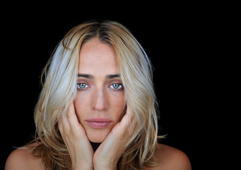 Lonely and depressed young woman on black background.