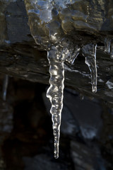 Naklejka na ściany i meble Close up of icicles hanging from a cliff