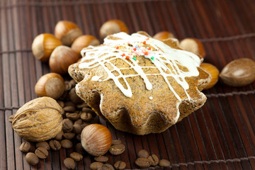 cake with icing, coffee beans and nuts lying on a bamboo mat