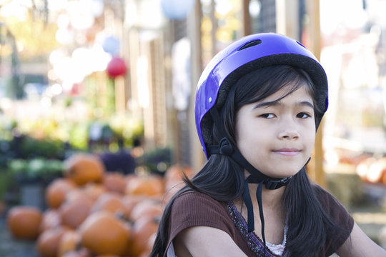 Little Girl With Purple Bike Helmet On Bicycle