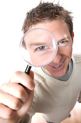 young smiling man looking through magnifying glass