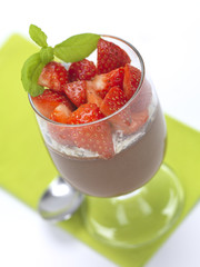 a chocolate flavor dessert in a glass with strawberries