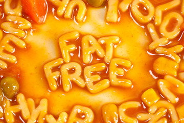Alphabet shaped pasta forming FAT FREE in tomato sauce