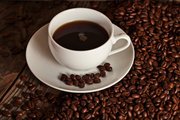 Cup of coffee sits on an old table.