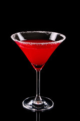 Martini glass with red coctail on black background
