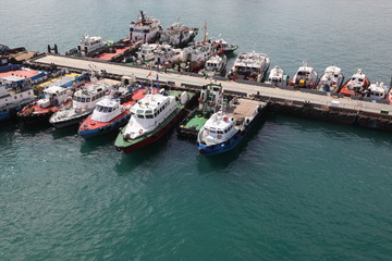 many cutters at its mooring in port. People on their cutters.