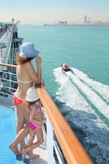 woman and daughter standing on deck of cruise ship