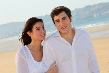 Obraz premium Portrait of lovely couple walking on the beach