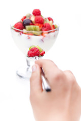 Hand hält Löffel mit Früchten vor Nachspeise I