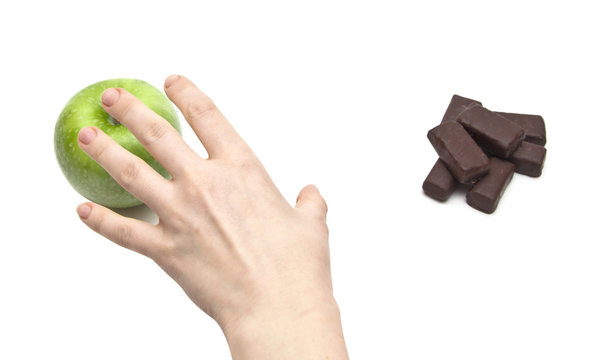 hand women choosing apple against chocolate