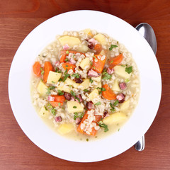 Barley soup on a wooden background