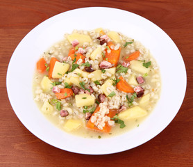 Barley soup on a wooden background