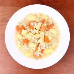 Barley soup on a wooden background
