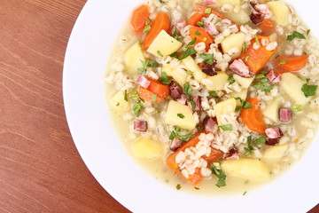 Barley soup on a wooden background