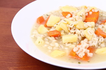 Barley soup on a wooden background