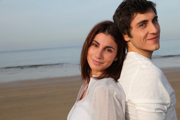 Obraz premium Young happy couple standing on a beach