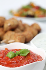 Tomato dip and roast meatballs in background