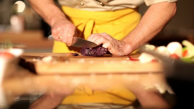 Profi Koch schneidet eine vitelotte Kartoffel