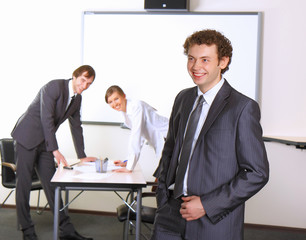 Business man with team mates discussing in the background