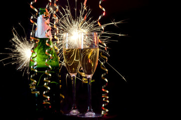 Bottle of champagne, two glasses, ribbons and sparklers.